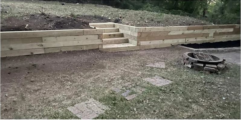 After view: Wooden retaining wall and steps on a wooded slope