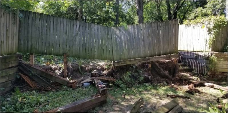 Before view: Worn wooden retaining wall in a wooded yard
